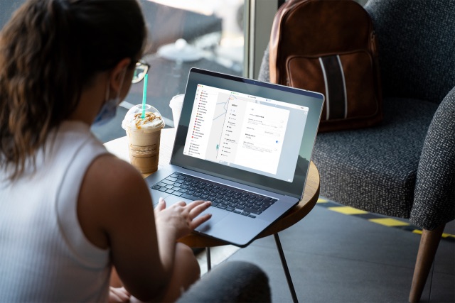 Digital nomade au travail sur le wifi d'un café, sac à dos posé à côté