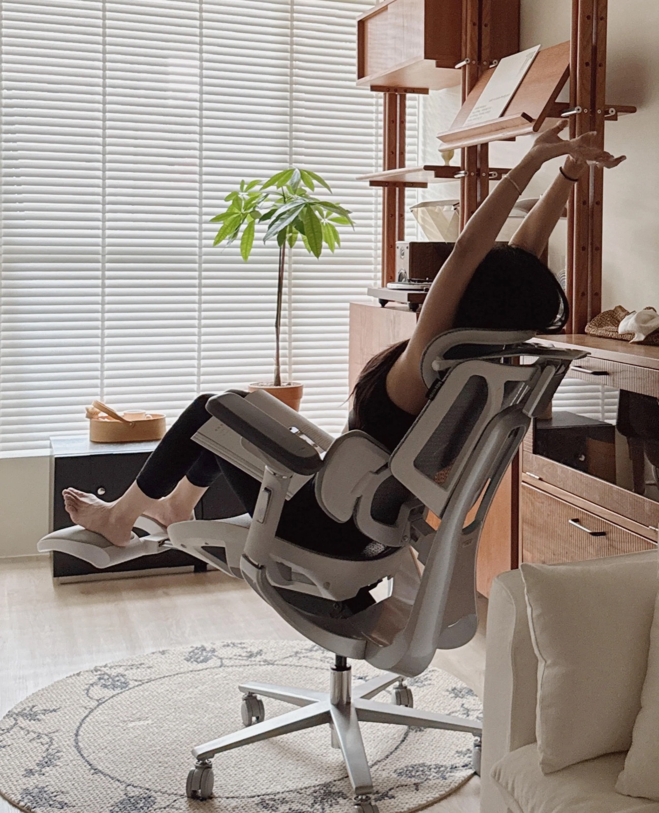 Personne inclinée dans la Hbada E3 Pro, jambes posées sur le repose-pieds escamotable déployé