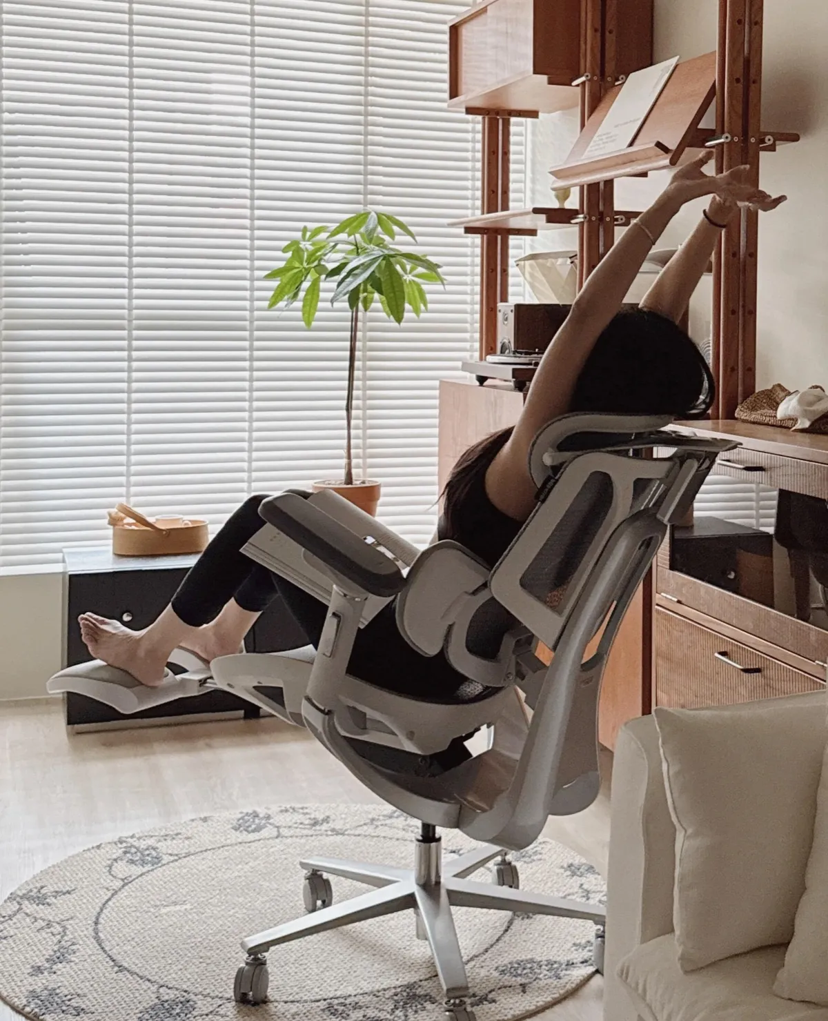 Personne inclinée dans la Hbada E3 Pro, jambes posées sur le repose-pieds escamotable déployé