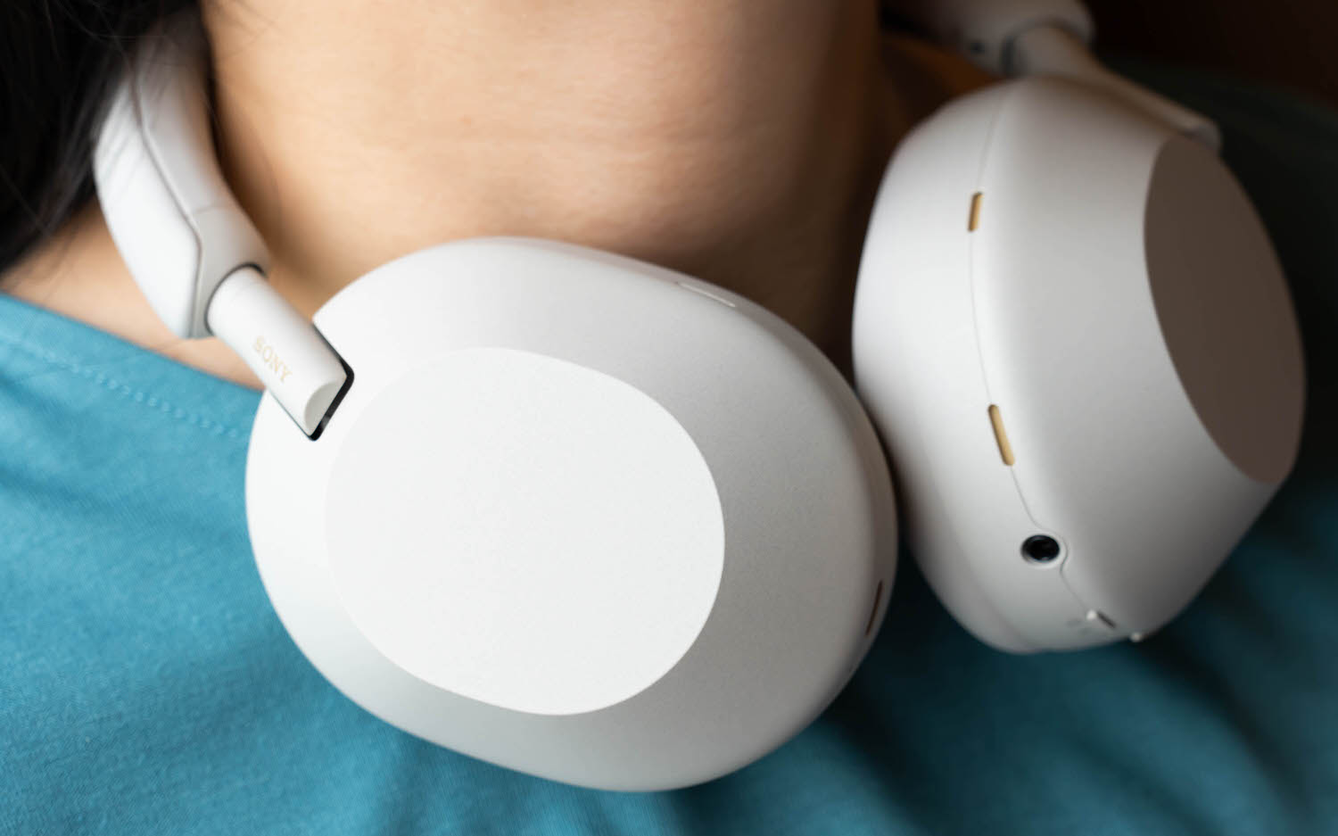Sony WH-1000XM5 blanc porté autour du cou