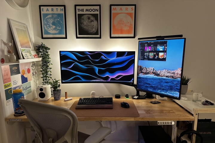 Écran vertical sur bras articulé à côté d'un ultrawide incurvé