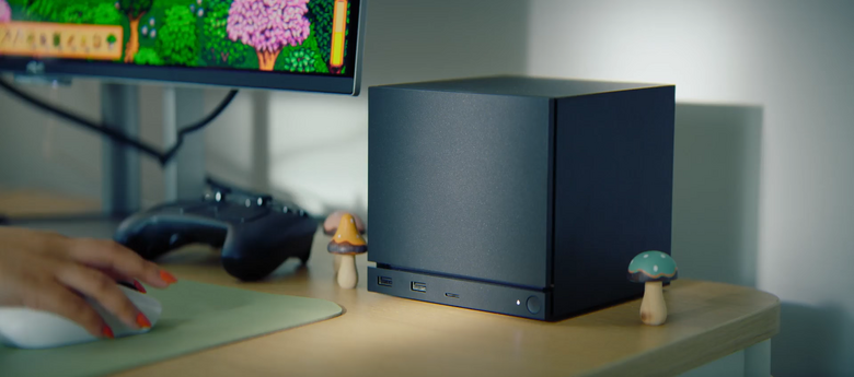 La Steam Machine sur un bureau cozy, manette et jeu à l'écran