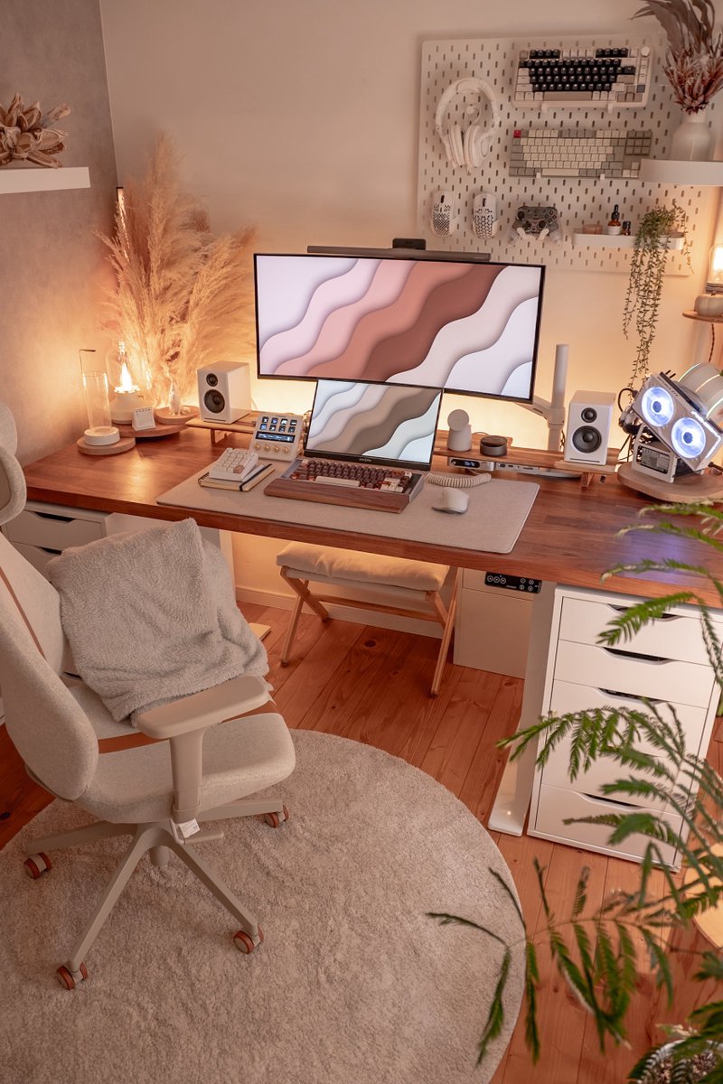 Bureau cosy à lumière chaude avec plaid sur la chaise, plante, lampe à poser et tapis rond crème