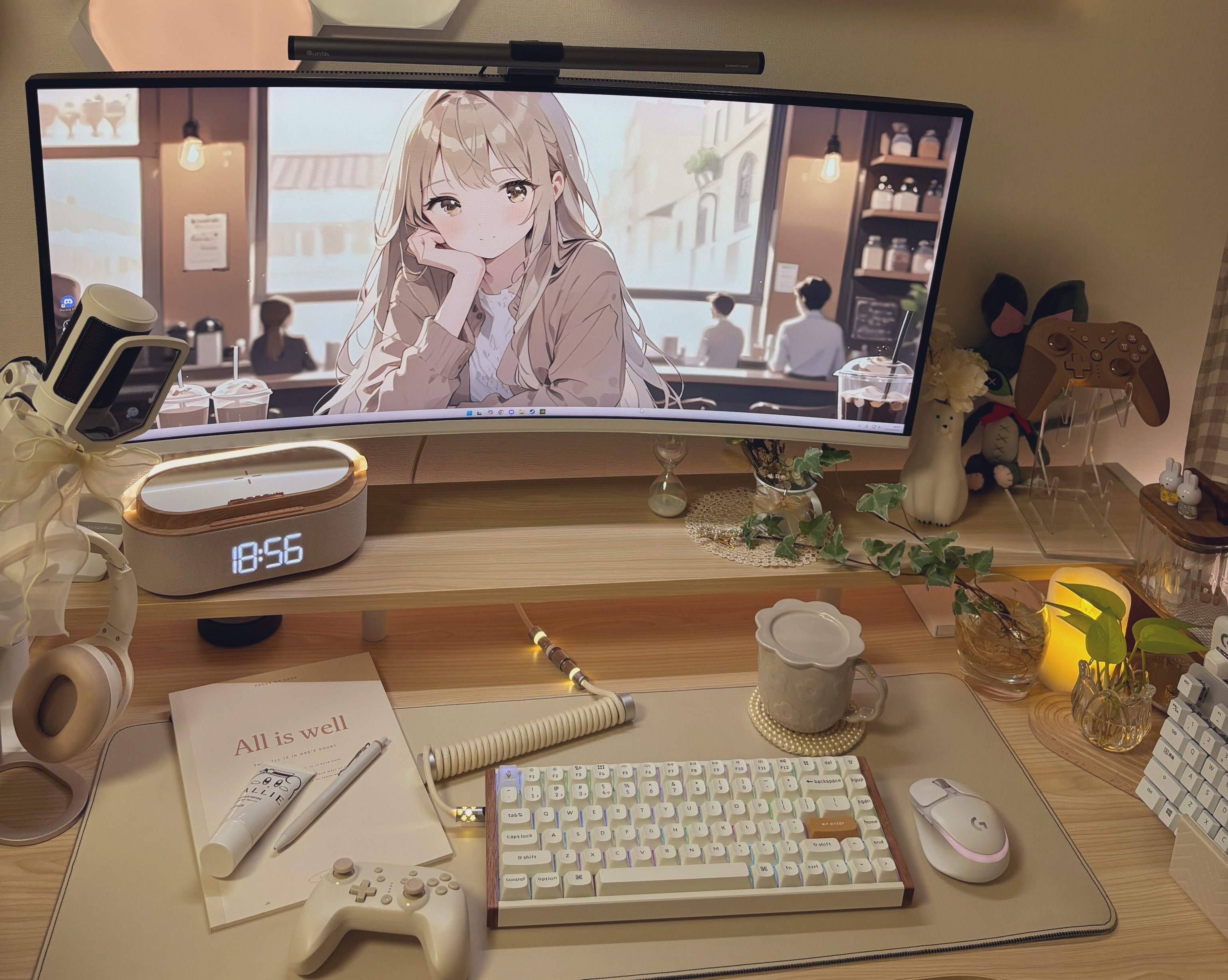 Setup cosy crème à lumière chaude avec écran incurvé, clavier blanc, mug fleuri, plantes et bougie