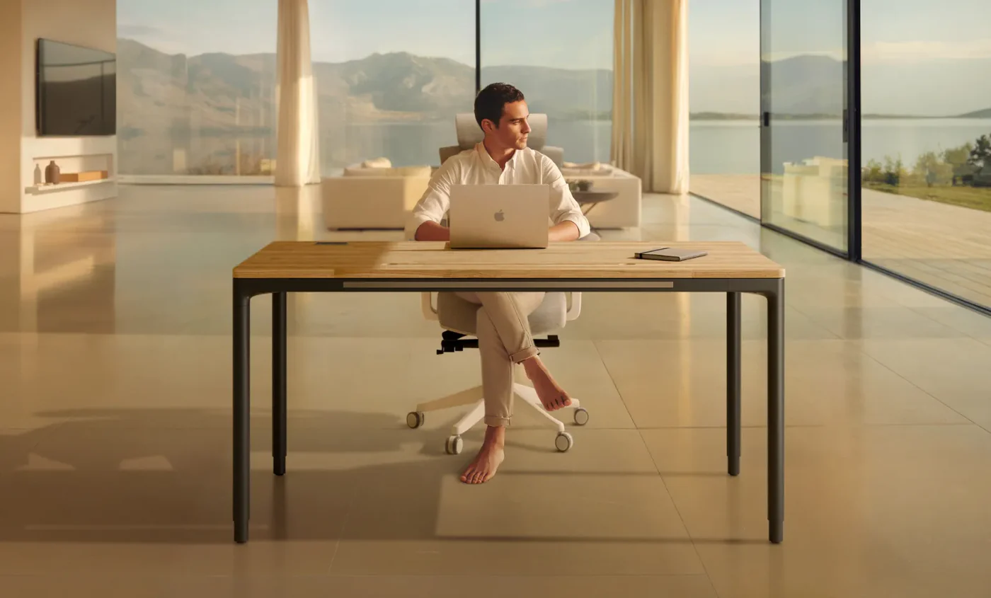 Homme travaillant à un bureau Desktronic HomeMax au plateau bois dans un salon lumineux