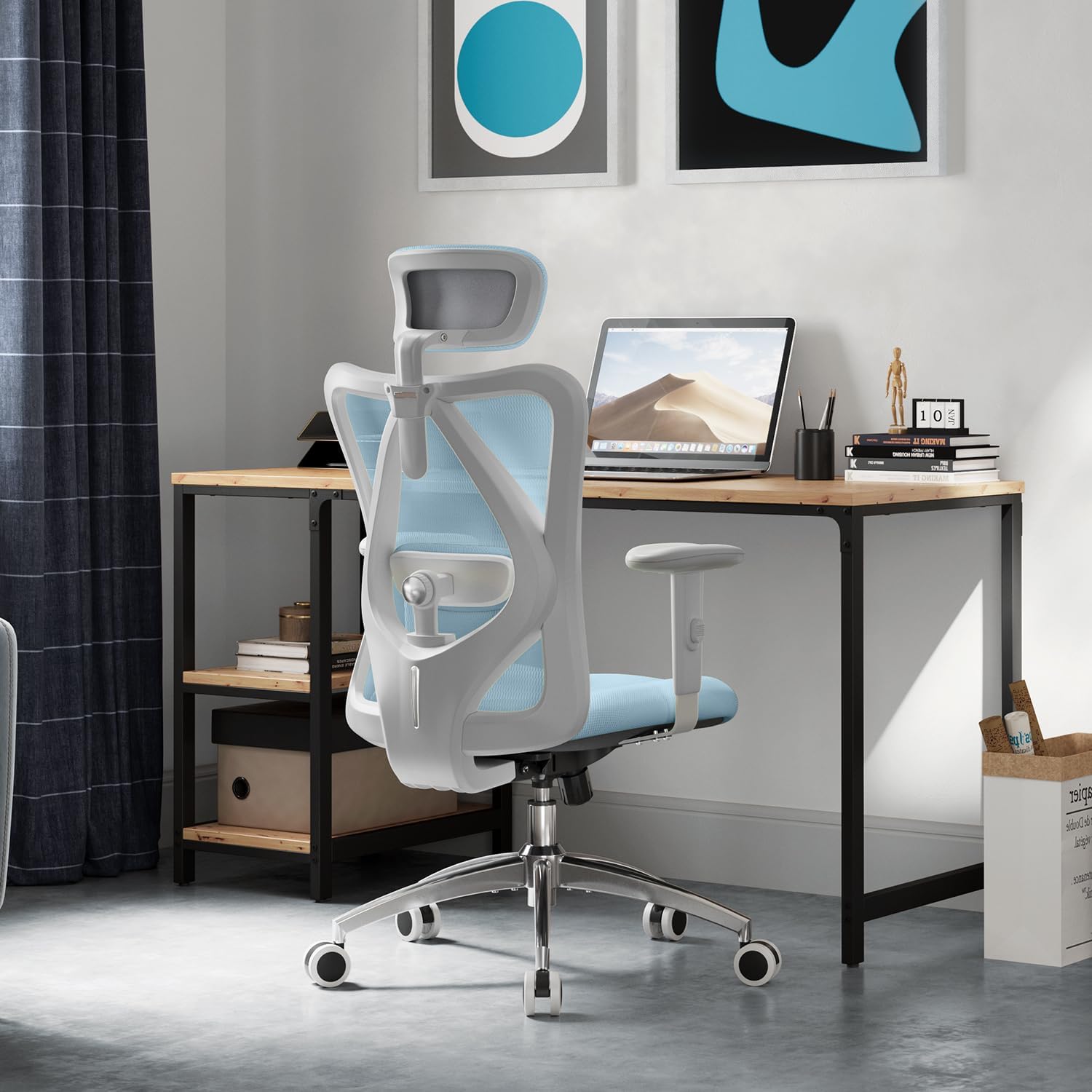Chaise de bureau Sihoo M18 coloris bleu installée à un bureau en bois dans un intérieur lumineux