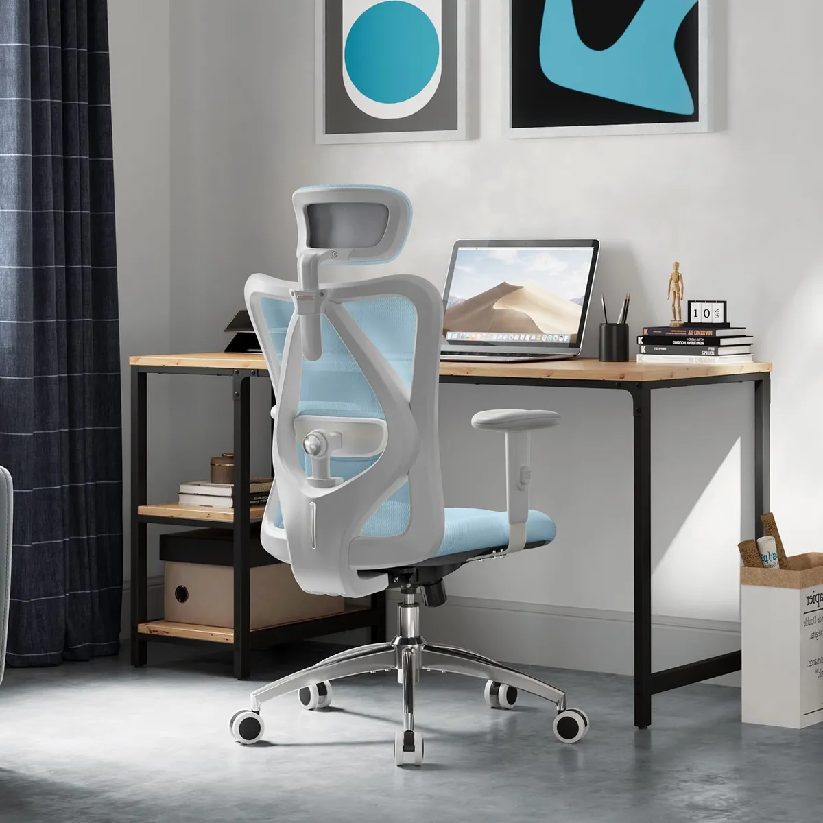Chaise de bureau Sihoo M18 coloris bleu installée à un bureau en bois dans un intérieur lumineux