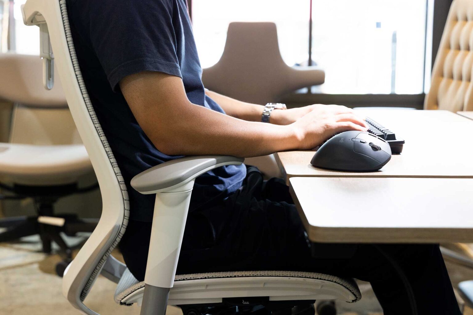 Posture de travail de profil, avant-bras posé et accoudoir réglé