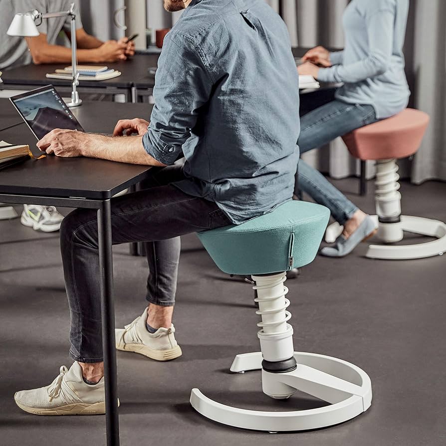 Deux personnes assises sur des tabourets-bascule Aeris Swopper dans un open space, tronc actif en posture de travail