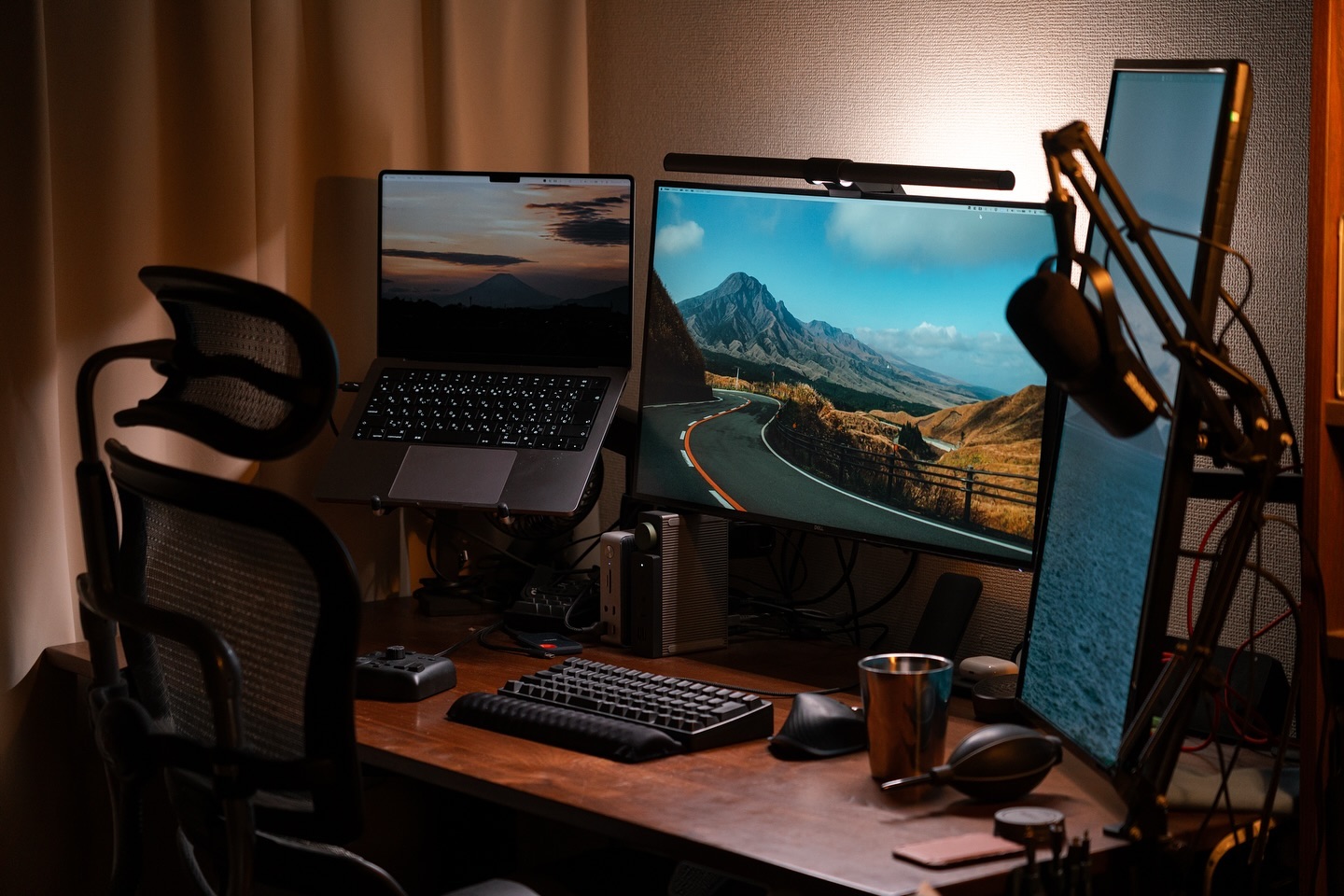 Grand écran type 32 pouces et écran vertical dans un bureau cosy le soir
