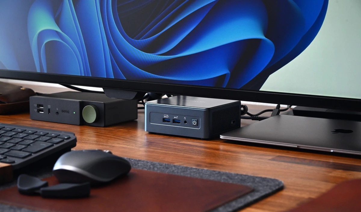 Mini-PC posé sous l'écran dans un setup de bureau épuré